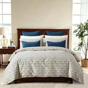 Motif duvet cover set with a blue and green block print on ivory and matching pillowcases styled on a bed.
